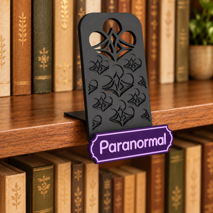Paranormal genre sign attached below the black book display shelf at the bookshelf edge. Example colors shown.