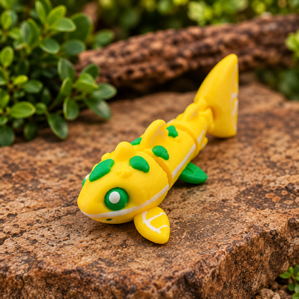 Yellow Micro Lemon Shark miniature with green accents, displayed diagonally on a wooden surface.