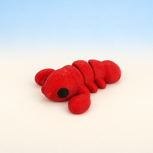 Micro Lobster 3D-printed miniature featuring a red body, large claws, and a segmented tail, on a light surface with a pale blue background.