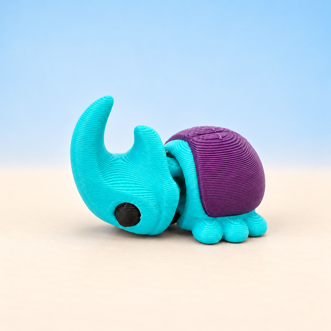 Micro Rhinoceros Beetle miniature in Turquoise and Purple, individual variant photo.