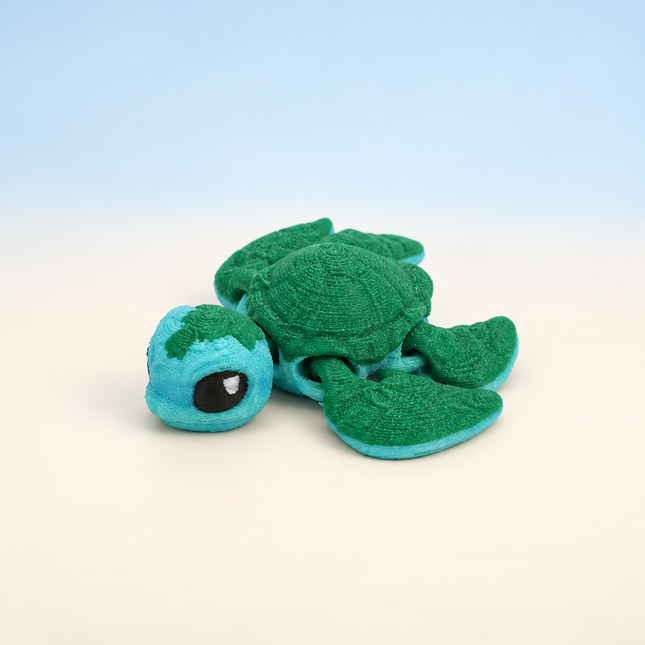 Micro Sea Turtle 3D-printed miniature featuring a green body, textured shell, and broad flippers, on a light surface with a pale blue background.