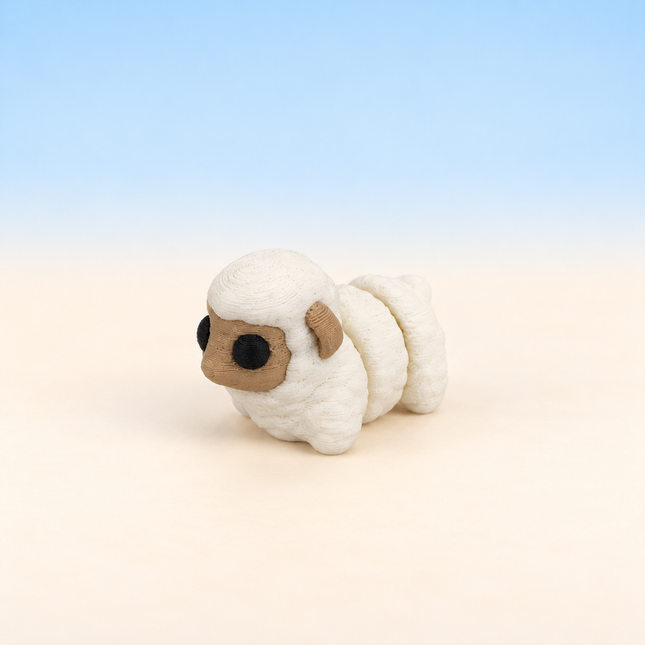 Micro Sheep 3D-printed miniature featuring a cream-colored woolly body and a rounded face, on a light surface with a pale blue background.