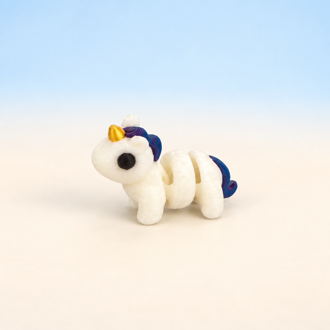Micro Unicorn 3D-printed miniature featuring a white body, small horn, and colorful mane and tail, on a light surface with a pale blue background.